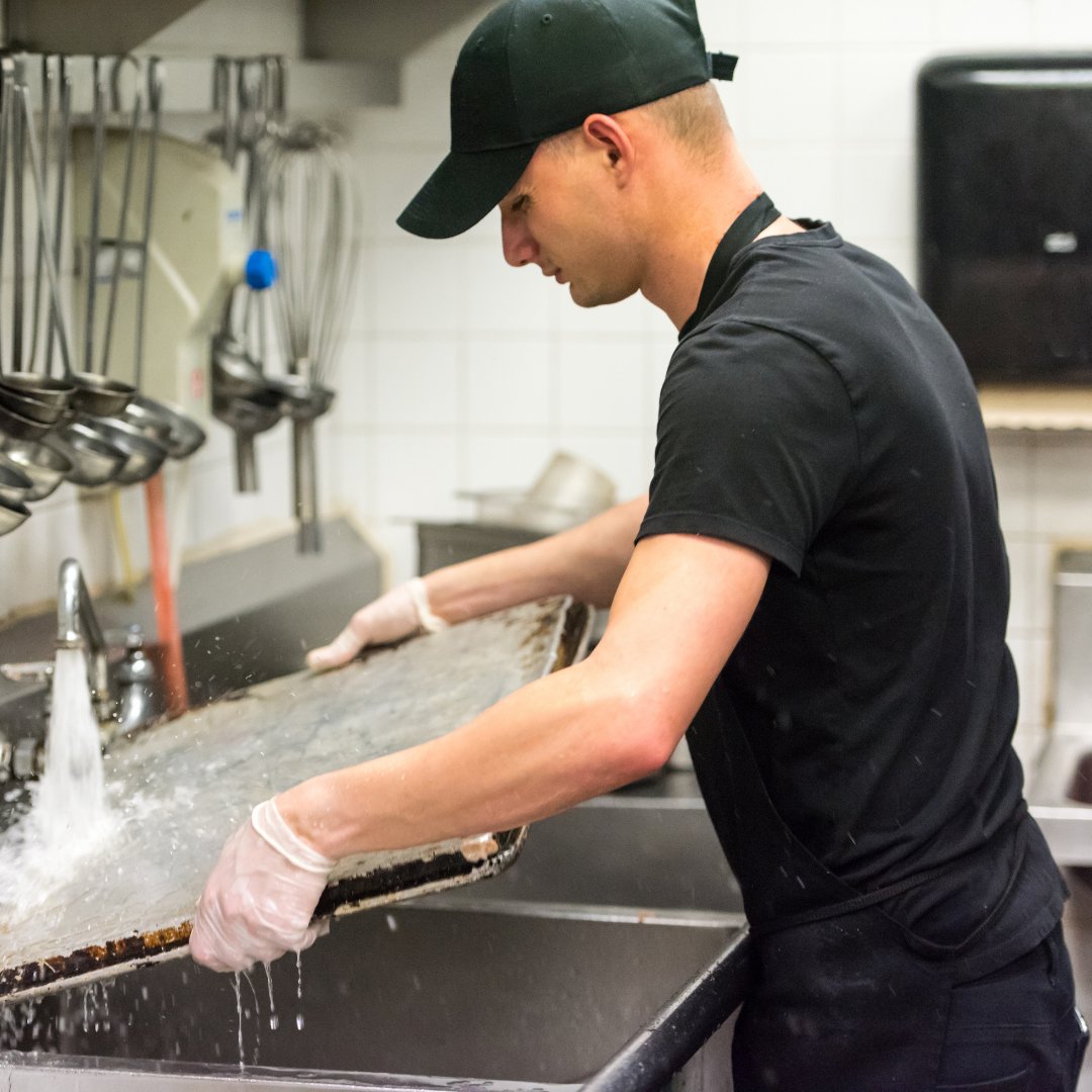 Kitchen worker cleaning trays